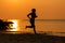 Silhouette athletic woman jogging exercise and relax and freedom on sand beach.