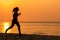 Silhouette athletic woman jogging and relax and freedom on sand beach. People running and workout in sunset background.