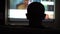 Silhouette of a Bald Head on the Background of the TV. The Concept of a Pleasant Pastime at the Moment of Self-isolation