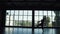 Silhouette of a ballet dancer male against the background of a large window. the dancer makes a high jump. slow motion