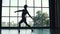 Silhouette of a ballet dancer male. young man dancing classic ballet on the background of a large window. slow motion
