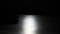 Silhouette of basketball player dribbles ball practicing skills in a dark studio with smoke and backlight. Male feet