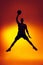 Silhouette of basketball player in motion, action isolated on gradient yellow orange background in neon light. Sport