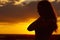 Silhouette of a beautiful romantic girl at sunset , face profile of young woman with long hair in hot weather