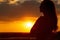 Silhouette of a beautiful romantic girl at sunset , face profile of young woman with long hair in hot weather
