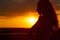 Silhouette of a beautiful romantic girl at sunset , face profile of young woman with long hair in hot weather