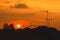 Silhouette of Beautiful sunset with television antenna or telecommunications towers, Orange sky with sun and cloud.