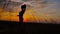 Silhouette of a beautiful teen girl standing on a background of gorgeous sunsets