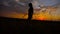 Silhouette of beautiful teen girl standing on a background of gorgeous sunsets