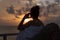 Silhouette of a beautiful woman contemplating sunrise from a balcony over the sea