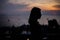 Silhouette of beautiful woman nearby the sea at the sunset.