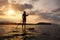 Silhouette of a beautiful woman on Stand Up Paddle Board.