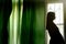 silhouette of beautiful woman standing at green curtains and loo