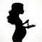 Silhouette of a beautiful young pregnant woman with lush hair eats vegetable salad