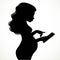 Silhouette of beautiful young pregnant woman uses an electronic tablet
