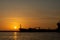 Silhouette of a big container ship at sunrise and exit from a