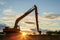 Silhouette of big tracked excavator digging the soil on site