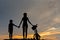 Silhouette biker lovely family at sunset over the ocean. Mom and daughter bicycling at the beach.