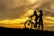 Silhouette biker lovely family at sunset over the ocean.  Mom and daughter bicycling chill and relax at the beach.