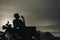 Silhouette of biker man sitting smokes with his motorbike beside the natural lake and beautiful, enjoying freedom and active lifes