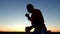 Silhouette of black sportsman fighting with a shadow in the sunset outdoor close up. Outlines of male boxer doing