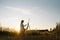 Silhouette of a blonde girl artist. Lady paints a painting on the canvas with the help of paints. A wooden easel keeps