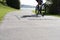 Silhouette of blurred in motion cyclists on shared pathway with sign in surface \\\