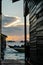 Silhouette of boats and unidentified man working early morning during sunrise.