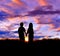 Silhouette of boy and girl stand hand in hand to watch the sunset