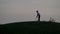 Silhouette of boy golfer with golf bag at sunset