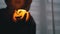 Silhouette of Boy in Hood. Hand Holds a Burning Pumpkin Candle in a Dark Room