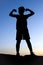 Silhouette of boy making a muscle pose