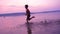 Silhouette of boy running along the shore of river