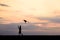 Silhouette boy running and flying a kite