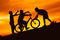 Silhouette boys riding bicycle at sunset or sunrise
