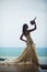 Silhouette of the bride against the sea. bride is considering her bouquet