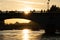 Silhouette of bridge Pont au Change with people over seine river at sunset in Paris, france