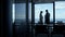 Silhouette business couple discussing panoramic window. Teamwork concept