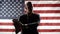 Silhouette of a business man taking an oath while holding his hand on the Constitution against the background of the American flag
