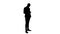 Silhouette Business man walks in checking up his phone