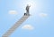 Silhouette of businessman standing on top of stairway with fist raised up on blue sky background