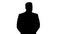 Silhouette Businessman walking and looking around holding hands behind his back.