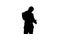 Silhouette Busy man talking on mobile phone and holding tablet PC