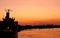 Silhouette cargo ship docked at port in sunset time