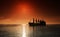 Silhouette of the cargo ship over the sunrise