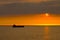Silhouette of the cargo ship over the sunrise.
