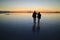 Silhouette of a caring couple exploring the incredible mirror effect of Uyuni Salt Flats, Bolivia, South America