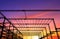 Silhouette of castellated beam of factory building structure in construction site against colorful sunset sky background