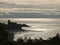 Silhouette of the castle of Lerici at sunset. Sky with clouds and sea of gold color