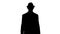 Silhouette Casual arabian man walking in a hat and with a briefcase.